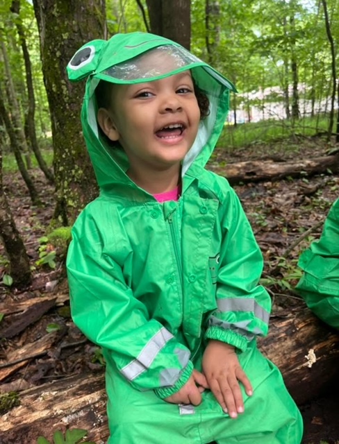 happy girl in a frog rainsuit